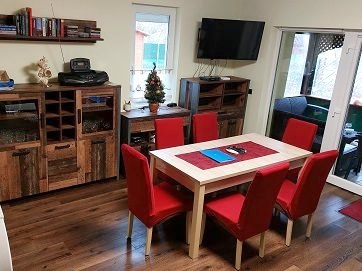 Az étkezőasztal piros székekkel, a teraszajtó mellett