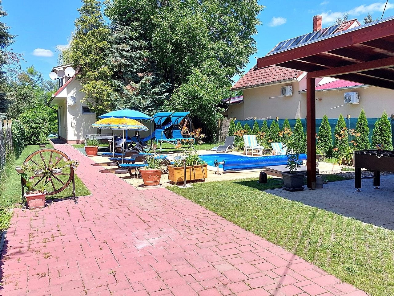 A medence és a fedett pihenő a térkövezett részen